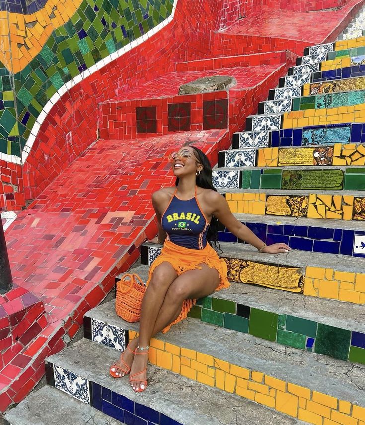 a woman sitting on the steps in front of colorful tiles