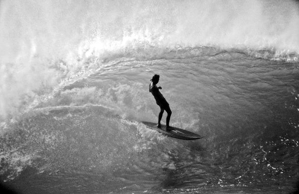 a man riding a wave on top of a surfboard