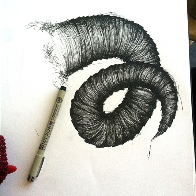 a drawing of a spiral design on paper with a marker next to it and a crayon pen