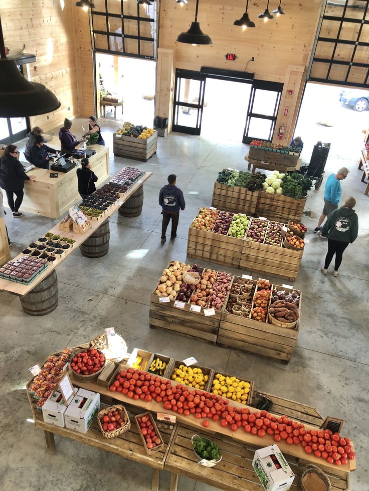 an overhead view of people shopping at a farmers market with lots of fresh fruits and vegetables