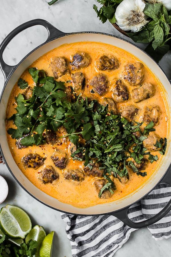 a pan filled with meatballs and cilantro sauce