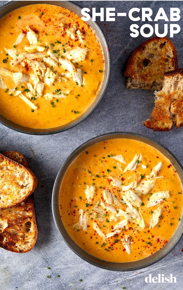 two bowls filled with soup next to slices of bread on top of a table and the words she crab soup