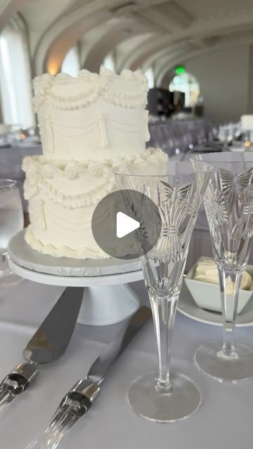 there is a wedding cake and wine glasses on the table with silverware next to it