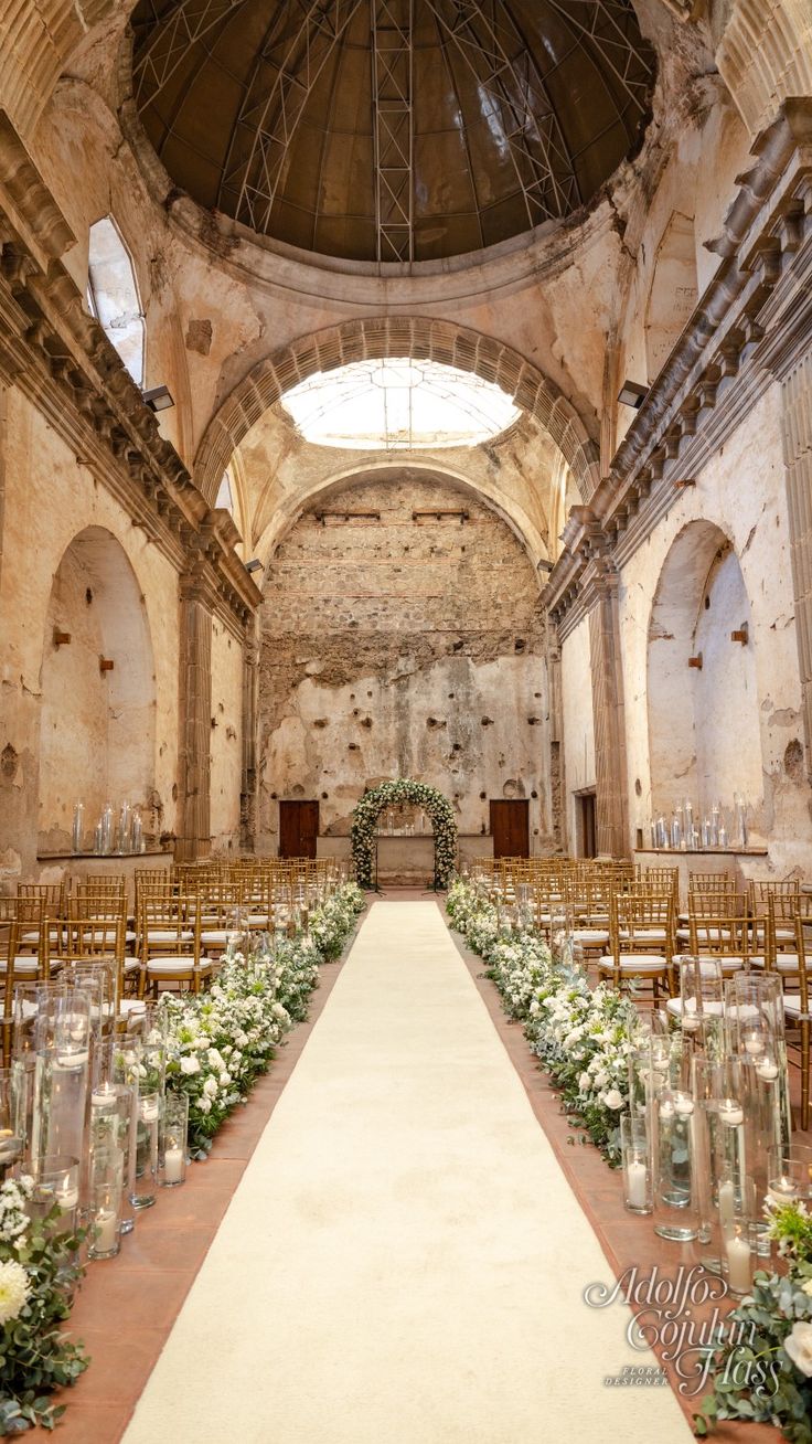 the aisle is lined with flowers and candles