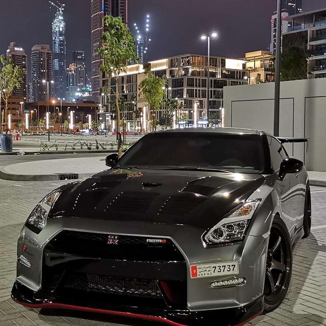 a nissan sports car parked in front of a cityscape