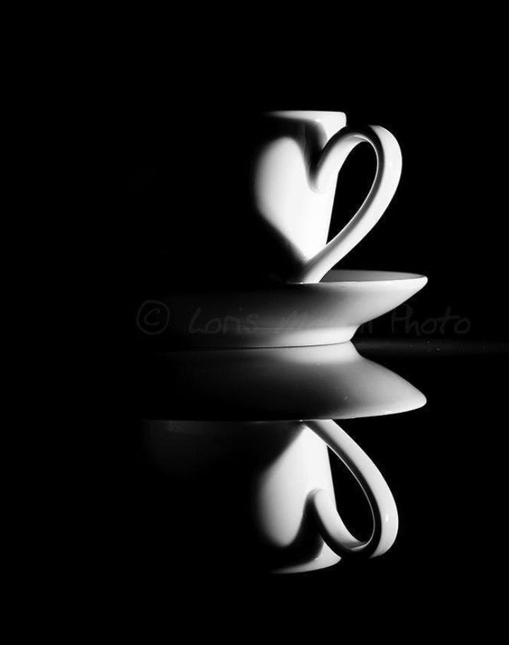 black and white photograph of two coffee cups stacked on top of each other in the shape of a heart