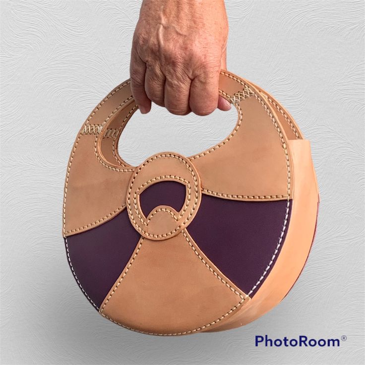 Lovely little handbag sewn with natural coloured veg tan leather. Decotation is purple veg tan leather. The bag has a round form. It is closed with a zipper. Design: treehousepatternsuk Dimensions of the bag: Diameter: 25 cm / 9.84'' Height: 15 cm ( 25 cm with the handle) / 5.90'' ( 9.84'' with the handle) Depth: 6.5 cm bottom - 3.5 cm top / 2.55'' bottom - 1.37'' top The bag will be sent without tracking. Should you wish for an upgrade, then please contact me before ordering. Brown Round Bag For Daily Use, Leather Bags With Round Handle For Gifts, Brown Bag With Round Handle Gift, Brown Shoulder Bag With Leather Lining And Round Handle, Leather Working Patterns, Hand Sewn Leather, Veg Tan Leather, Leather Projects, Leather Bags Handmade