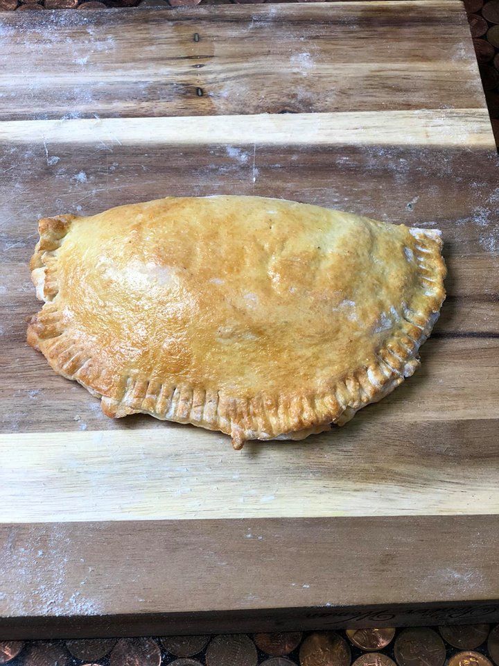 an uncooked pie sitting on top of a wooden cutting board