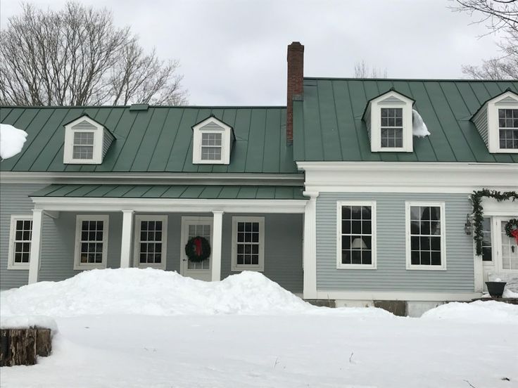 a house with a green roof and white trim