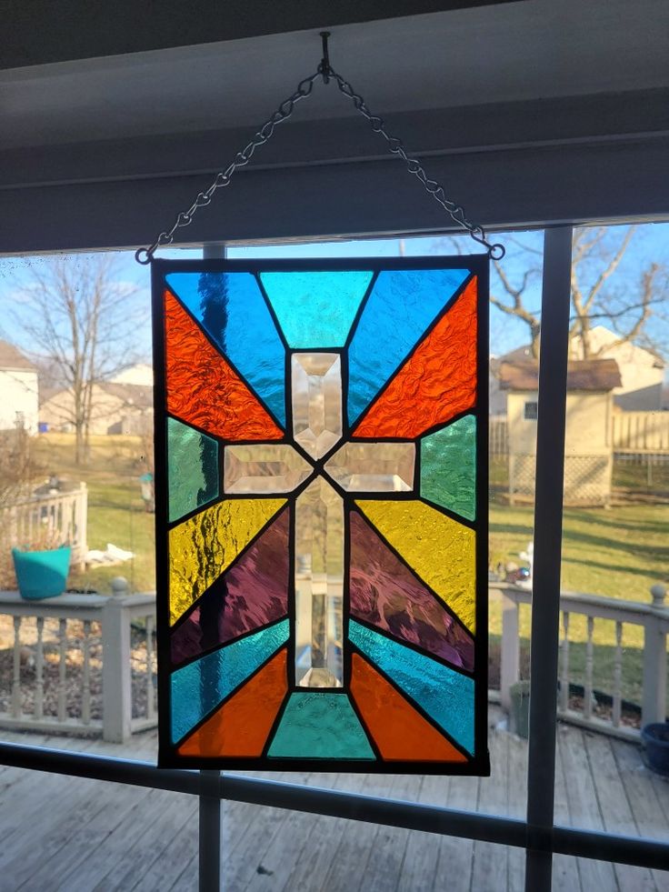 a stained glass window hanging on the side of a house