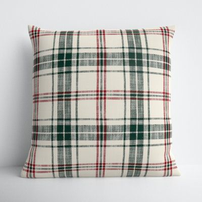 a plaid pillow sitting on top of a white table