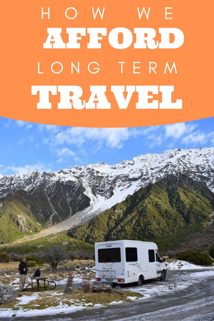 an rv parked on the side of a snow covered road with mountains in the background