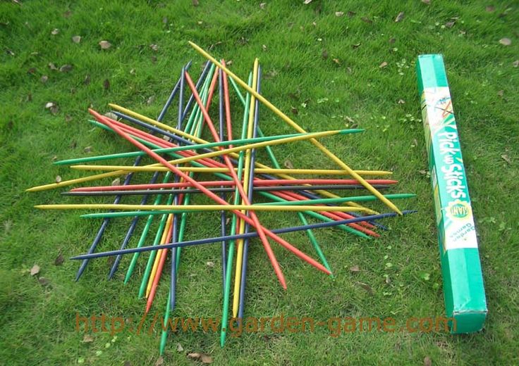 a bunch of colored pencils laying on the ground next to a green box and stick