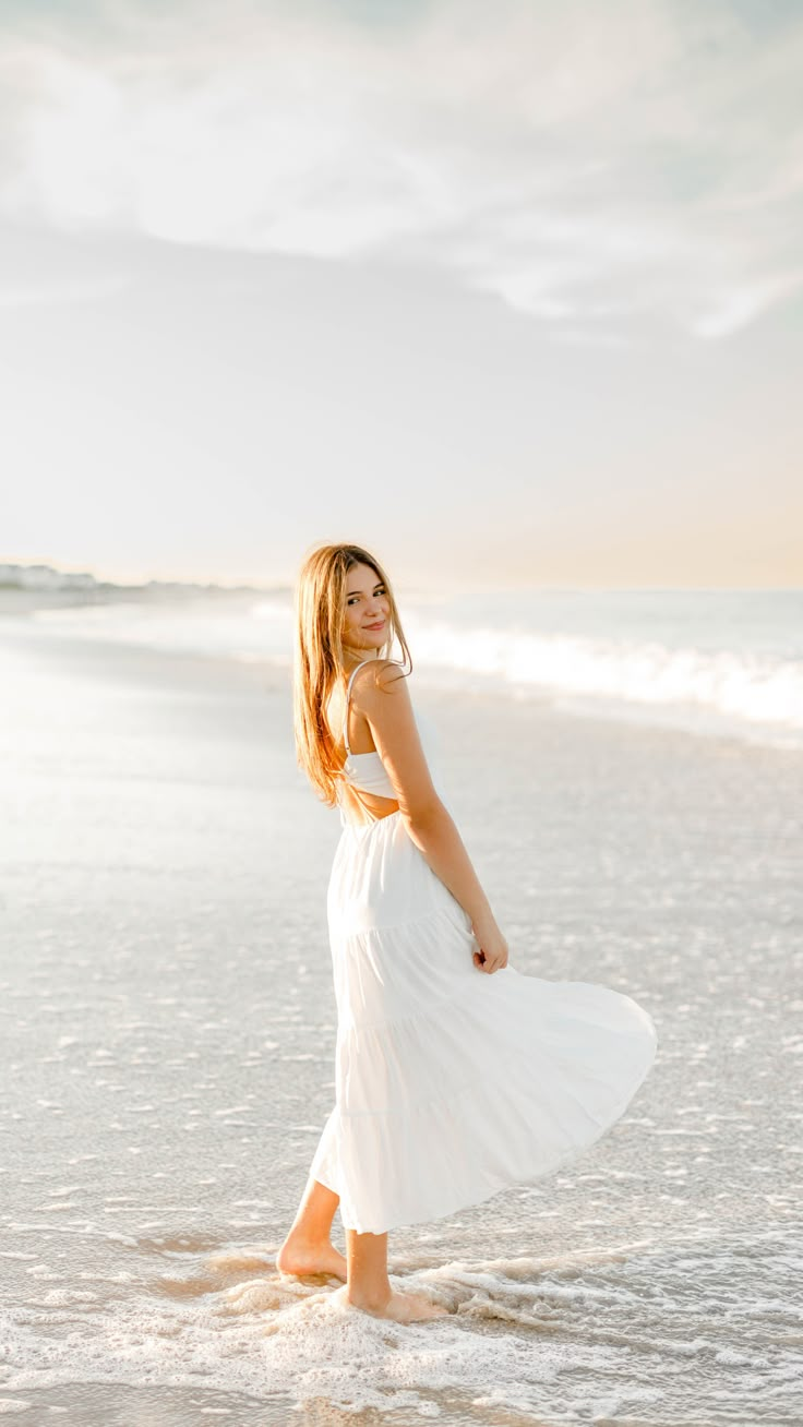 Girl wearing white dress standing in ocean at sunset Light Blue Senior Pictures, Senior Photos In The Water, Self Beach Pictures, Beach Pictures Portrait, Professional Beach Photos, Poses By The Beach, Beach Photoshoot Portraits, Beach Senior Session, Cute Beach Senior Pictures