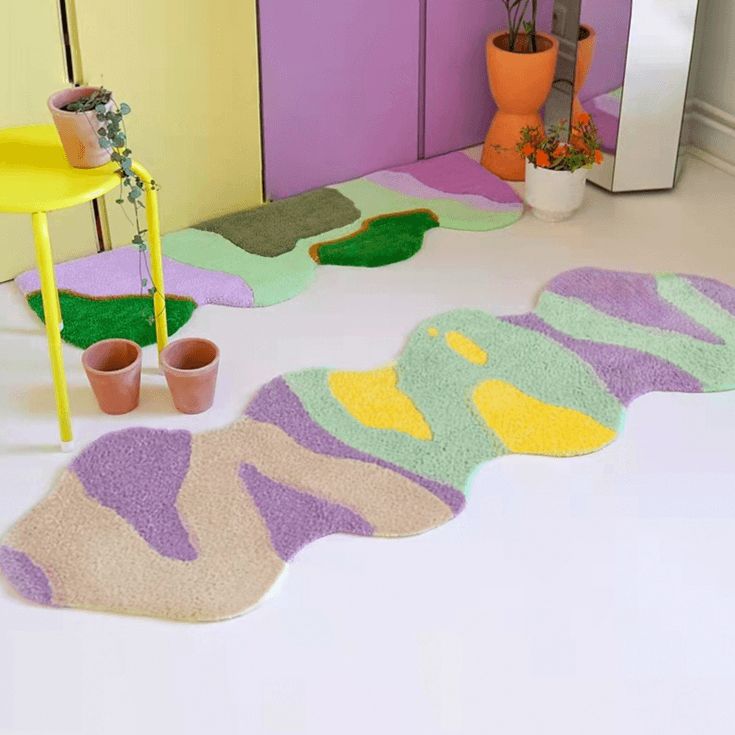 colorful rugs and potted plants are on the floor in front of a mirror