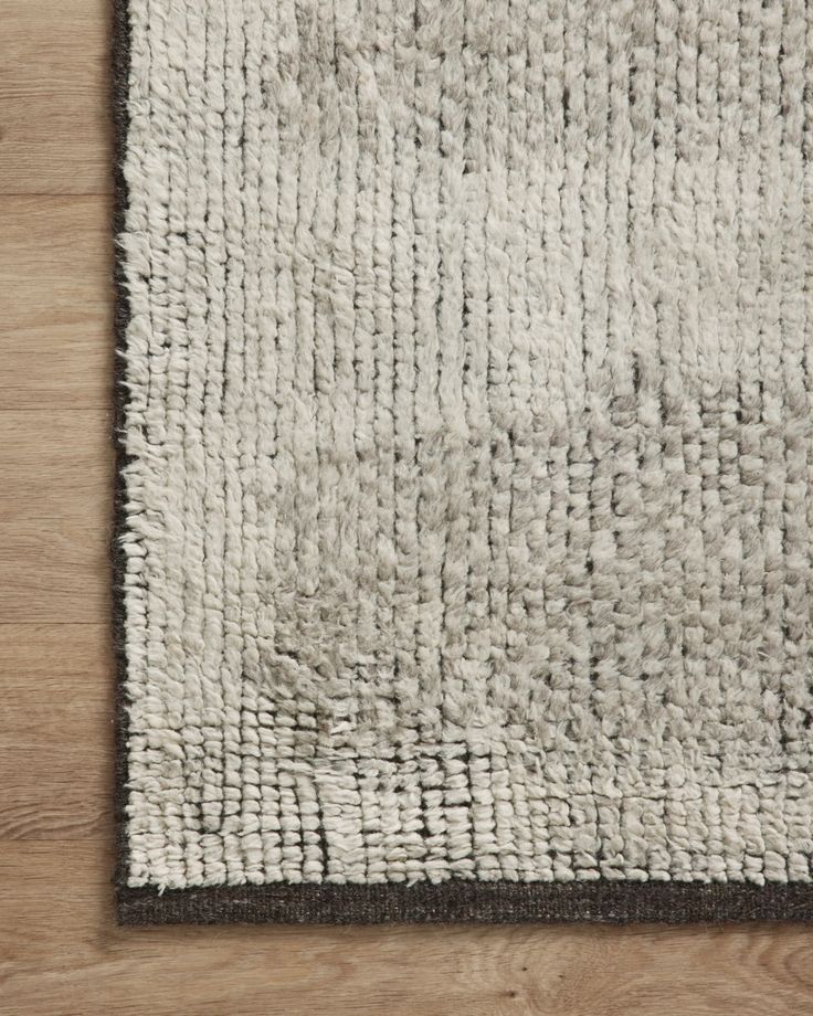 a white and brown rug on top of a wooden floor