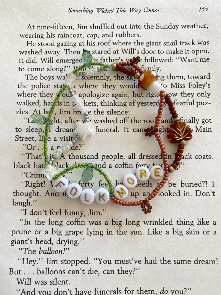 a book page with some beads on it and an image of the word love written in white