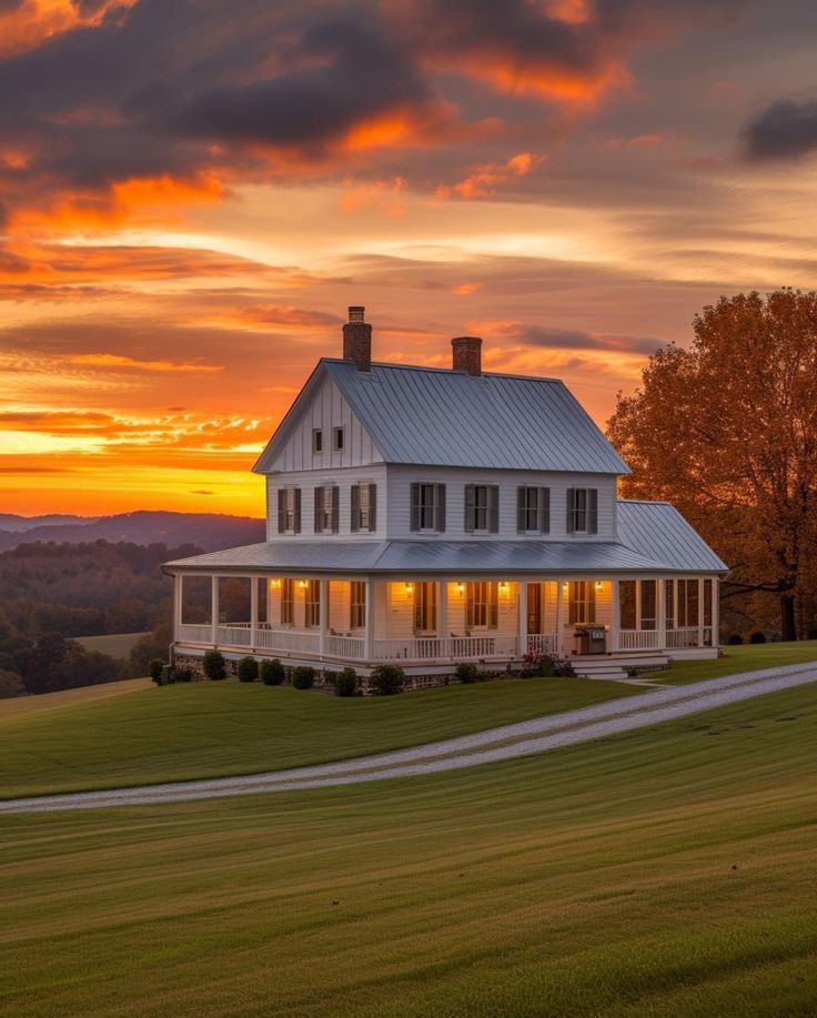 a large white house sitting on top of a lush green field under a cloudy sky