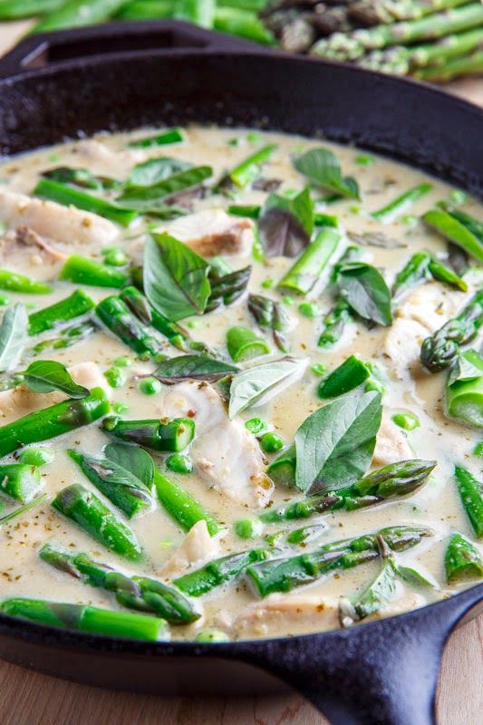 asparagus and chicken soup in a cast iron skillet on a wooden table