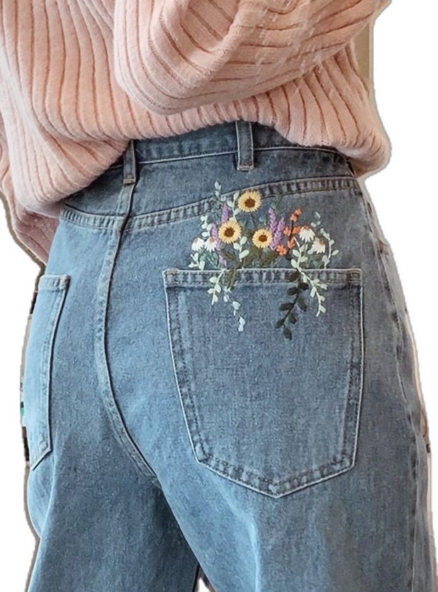 the back of a woman's jeans with flowers embroidered on it and an open pink sweater