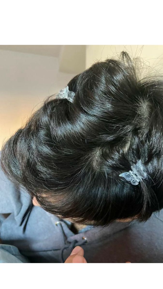 a woman is cutting her hair with scissors