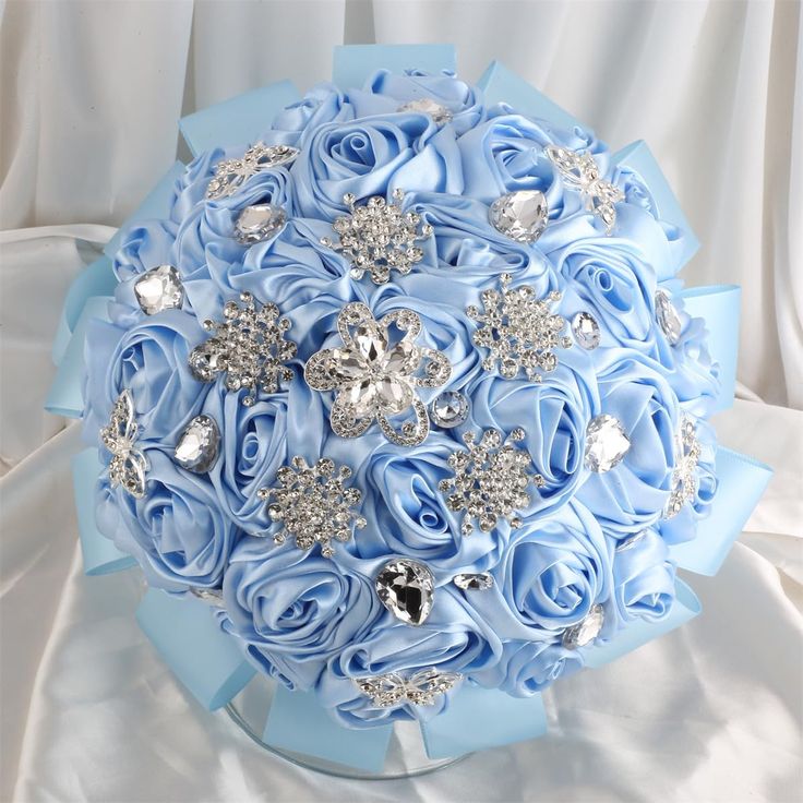 a bridal bouquet with blue roses and crystal brooches