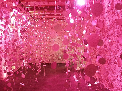 a room filled with lots of pink balloons