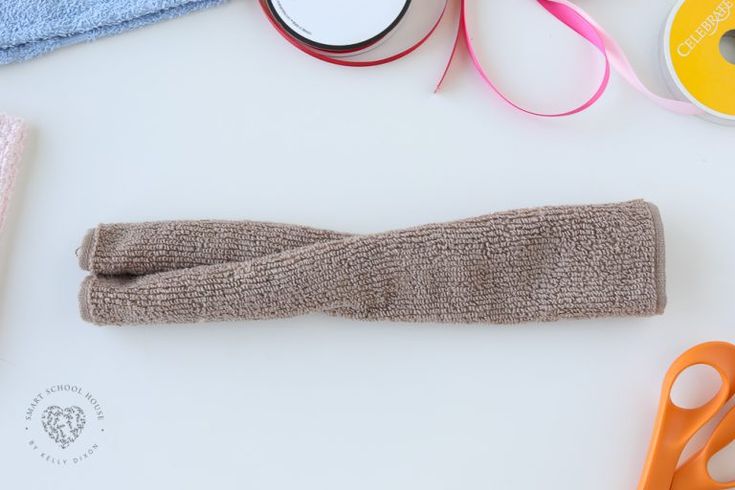 scissors, tape and other crafting supplies laid out on a white surface with one pair of scissors