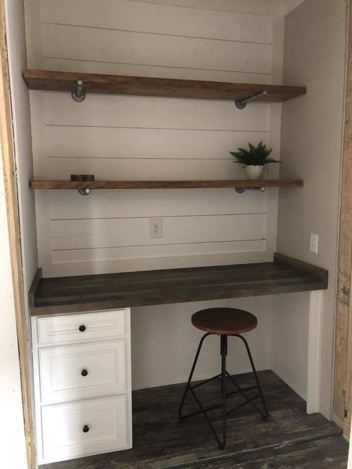 a room with some shelves and a stool in it's corner, next to a desk