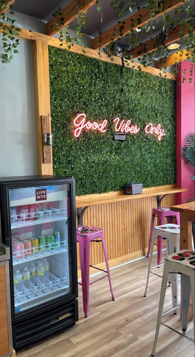 the interior of a restaurant with pink chairs and green walls on the wall behind it