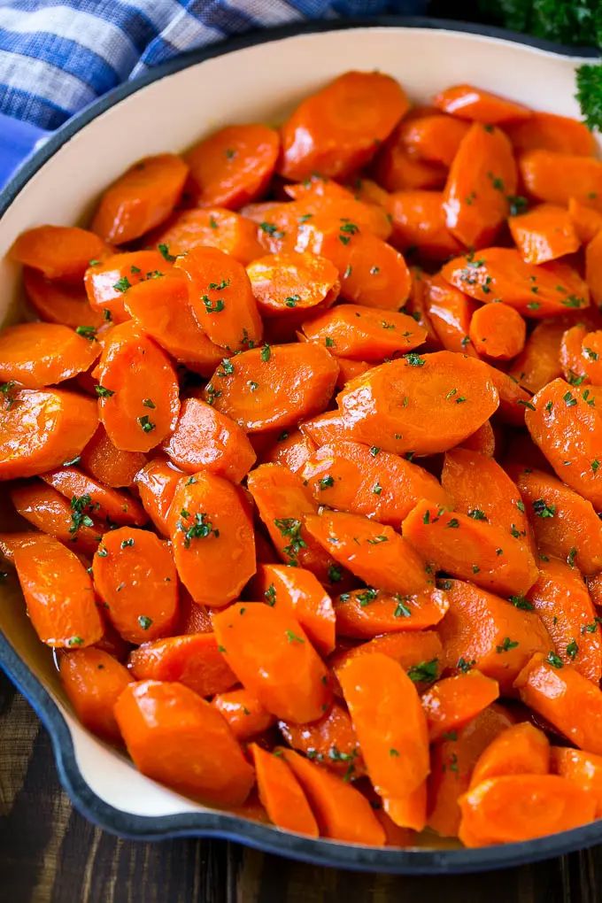 carrots in a white dish with parsley on the top and blue towel next to it