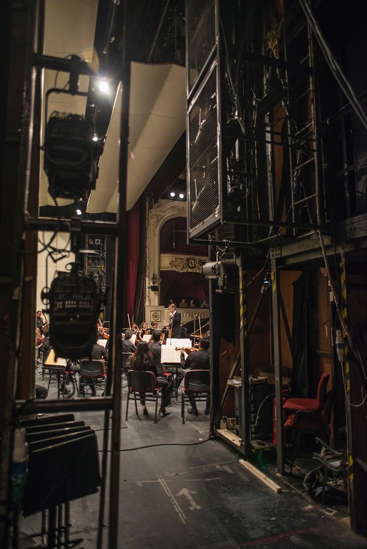 a group of people sitting at tables in front of a camera set up for a performance