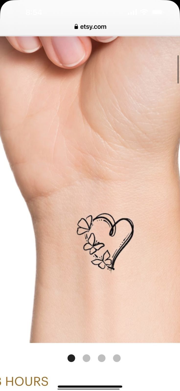 a small tattoo on the wrist of a woman's left arm, with an outline of a heart and flowers