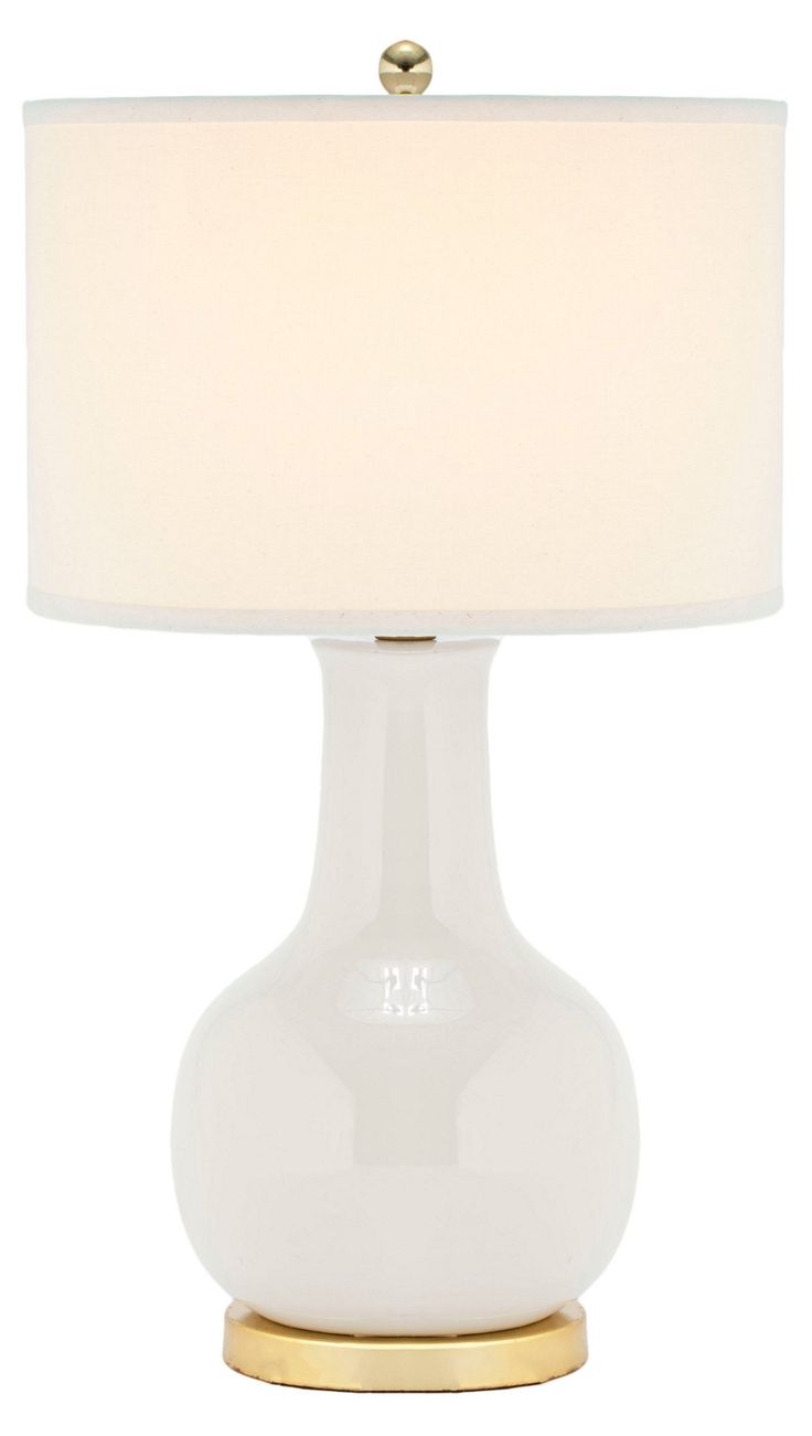 a white table lamp with a gold base