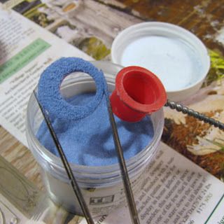 two yarns are sitting on top of a newspaper next to some scissors and thread