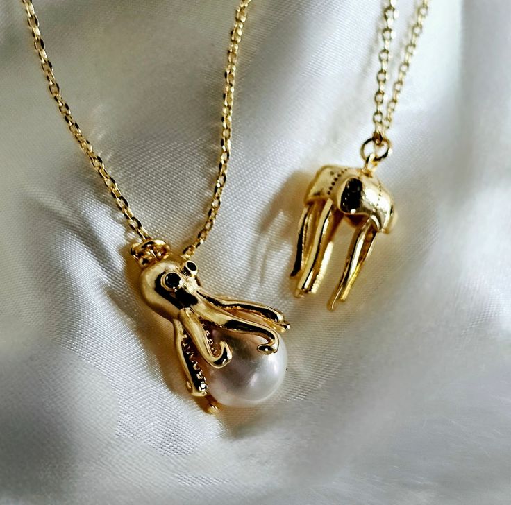 Dive into whimsy with this enchanting gold-plated necklace set. Featuring a quirky octopus pendant cradling a luminous shell pearl and a hollow jellyfish design, these unique pieces add a playful touch to any outfit. Perfect for ocean lovers and those who adore statement jewelry, this set is a delightful blend of elegance and fun. Pearls, known for their timeless beauty and elegance, are the perfect birthstone for June. Symbolizing purity, wisdom, and serenity, pearls add a touch of sophisticati Rose Gold Heart Charm Necklace, Mother's Day Gold Plated Dangle Jewelry, Whimsical Clavicle Chain Necklaces For Gifts, Whimsical Clavicle Chain Necklace For Gift, Adjustable Clavicle Chain Jewelry For Gift, Adjustable Collar Necklace Jewelry As Gift, Adjustable Clavicle Chain Jewelry As A Gift, Elegant Adjustable Charms Jewelry, Gold Plated Clavicle Chain Charm Necklace For Party