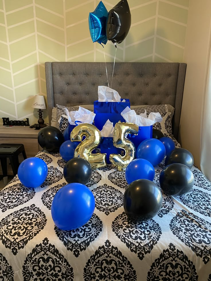 balloons and streamers are on the bed with blue and black decorations for new year's eve