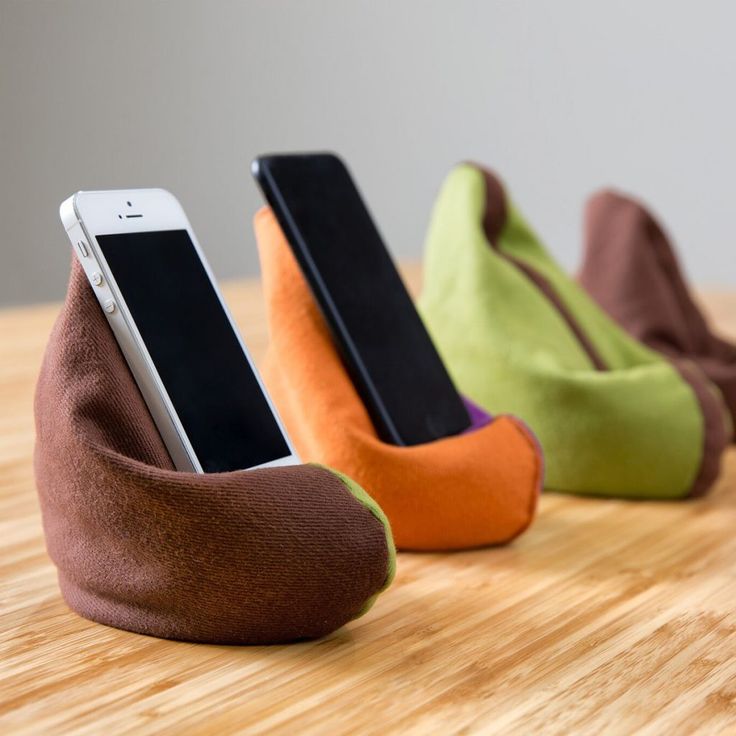 three cell phones are sitting in the shape of shoes on top of a wooden table