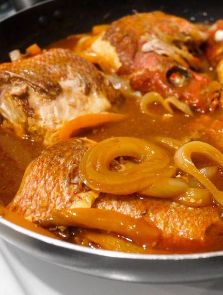 a pan filled with meat and onions on top of a stove