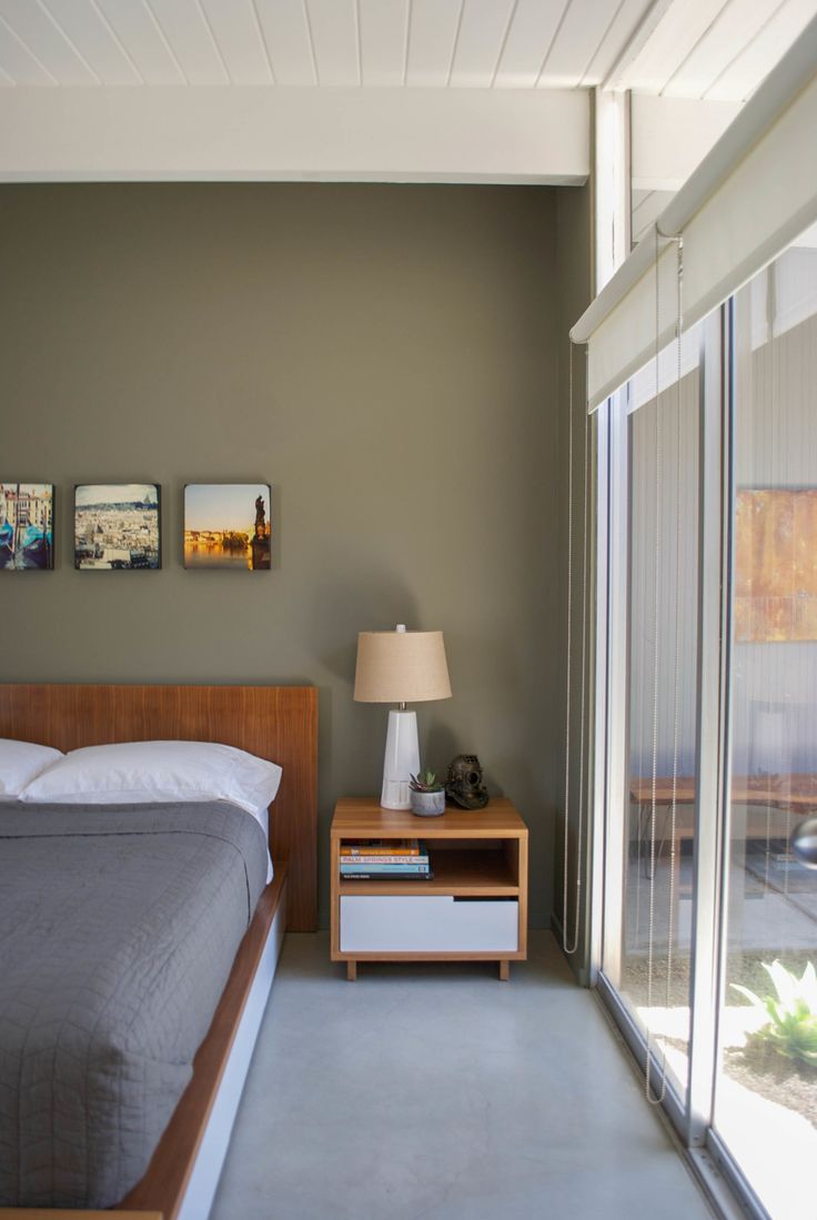 a bedroom with a bed, nightstand and sliding glass doors leading to an outside patio