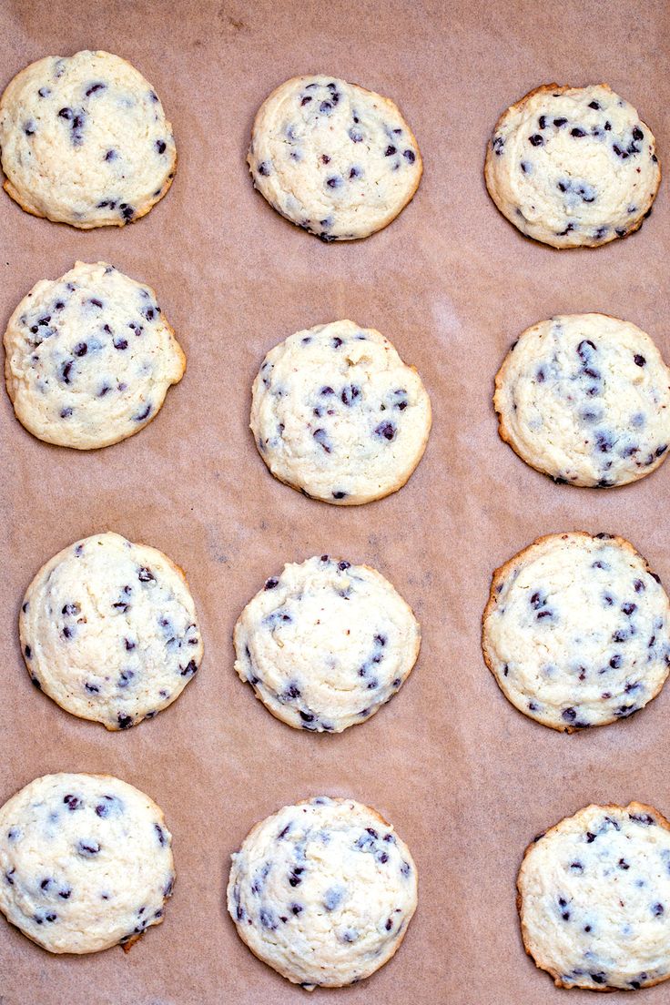 twelve chocolate chip cookies on a cookie sheet ready to be baked in the oven for baking