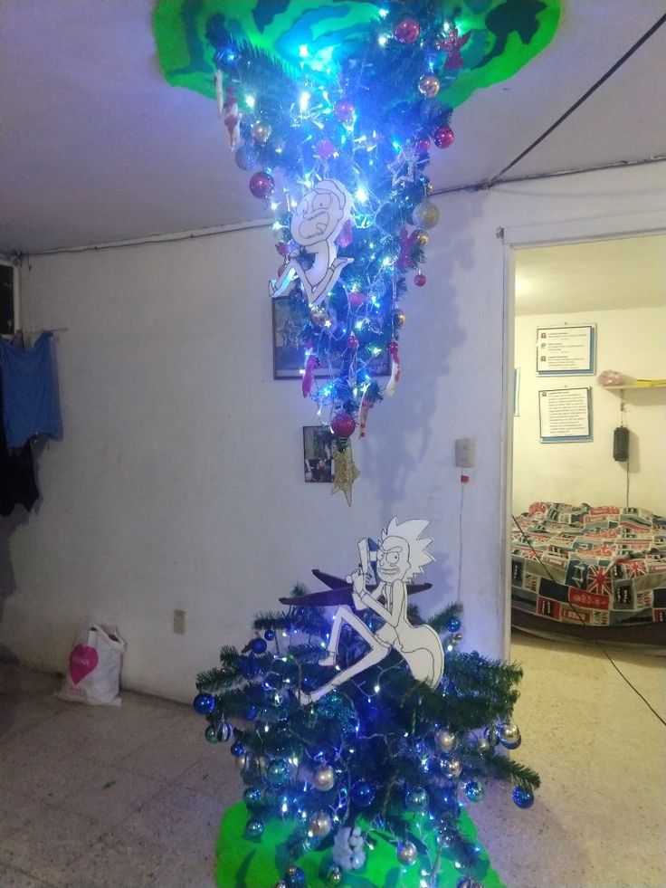 a christmas tree that has been decorated with lights and tinsels is in the corner of a room