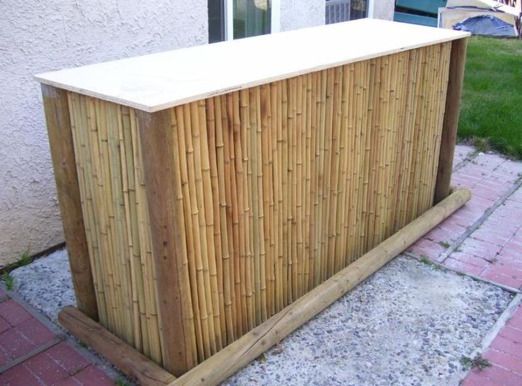 a wooden box sitting on the side of a building next to a grass covered yard