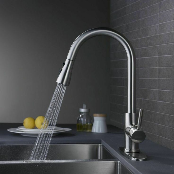 a kitchen faucet with water running from it and lemons on the counter