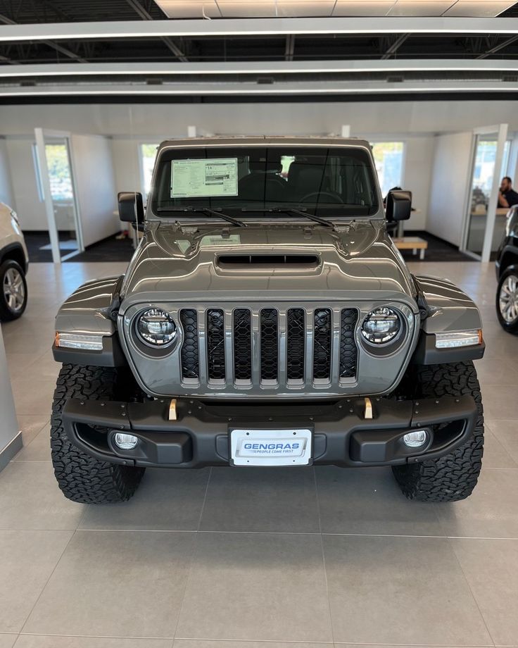 a jeep is parked in a showroom with other vehicles