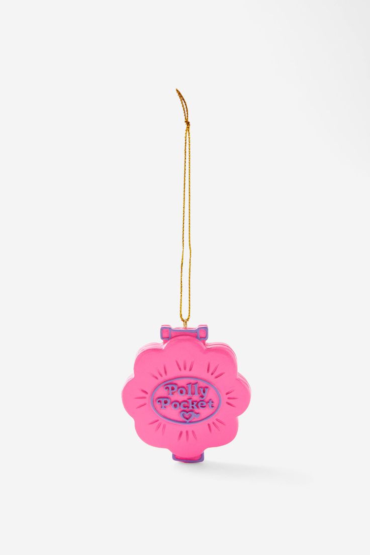 a pink ornament hanging from a gold chain