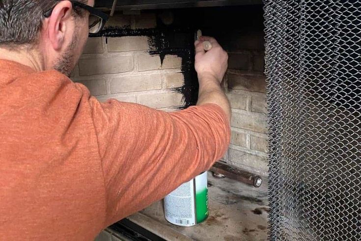 a man working on a fire in a brick oven