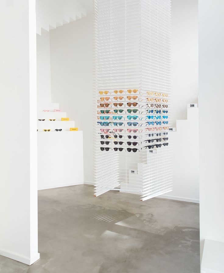 an art installation with multiple shades of sunglasses hanging from the ceiling and in between two walls