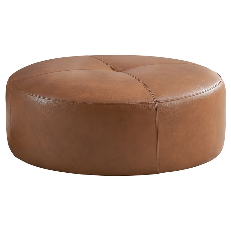 a large round leather ottoman sitting on top of a white floor