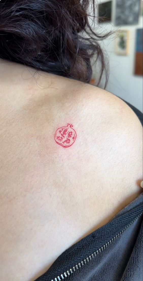 a woman with a red tattoo on her shoulder